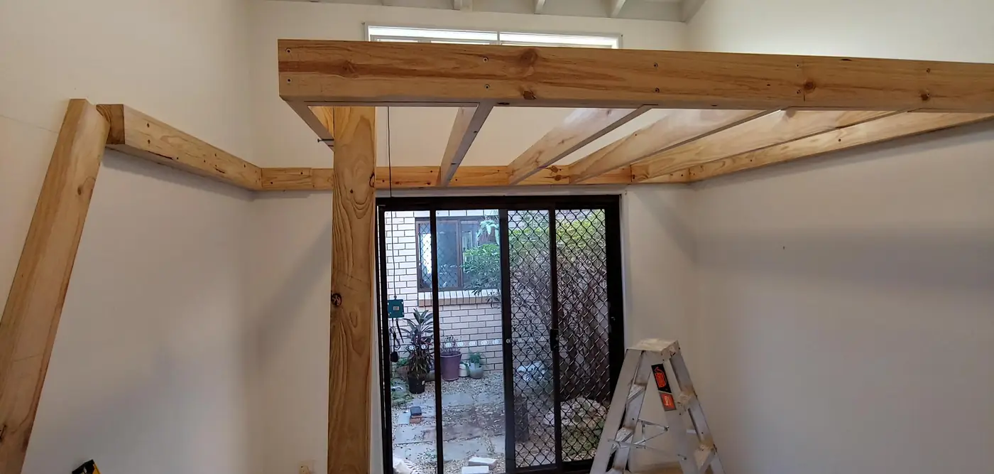Loft frame bolted into the walls of a high-ceiling room
