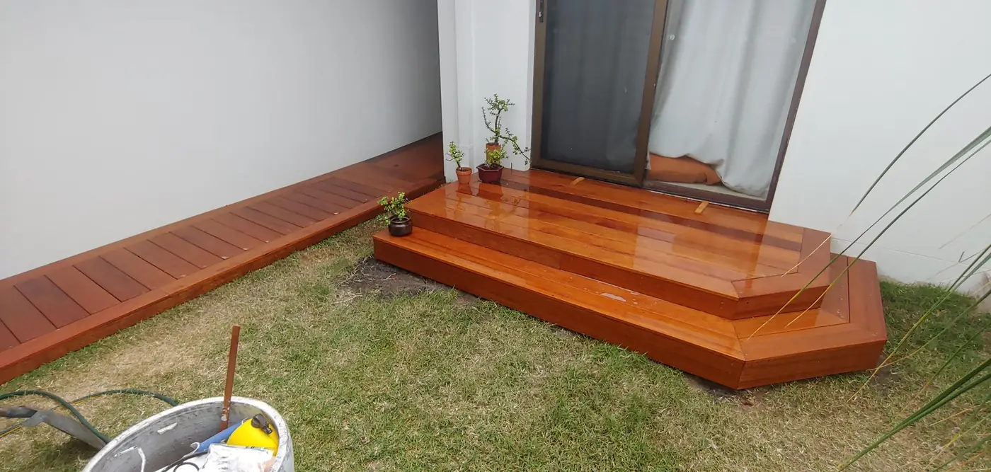 Hardwood step deck with angled corners outside a sliding door